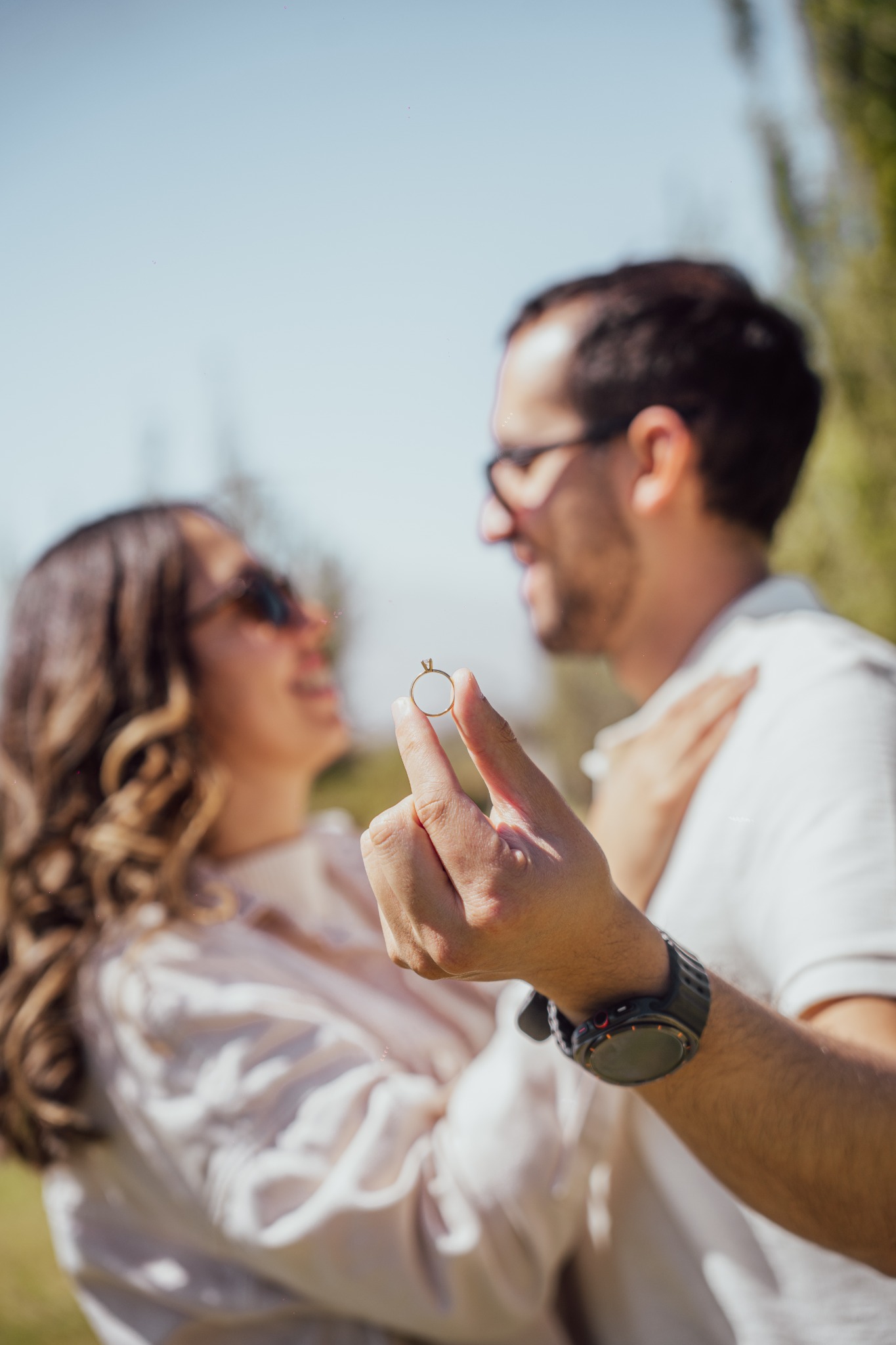 El anillo en primer plano y nosotros sonriendo al fondo